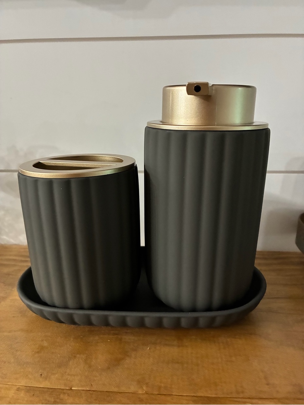 Three-piece matted, charcoal, gray, and gold bathroom accessories